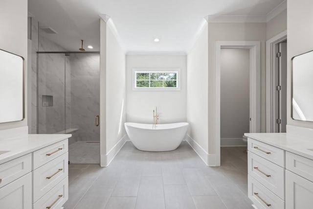 bathroom with ornamental molding, a soaking tub, vanity, and baseboards