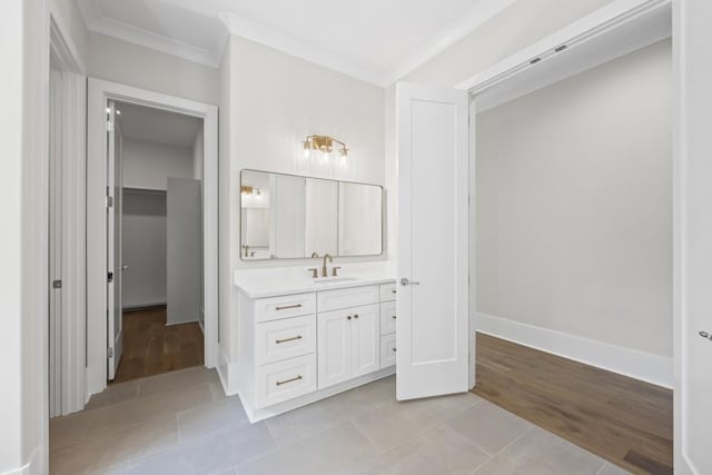 bathroom featuring tile patterned flooring, a spacious closet, crown molding, and vanity