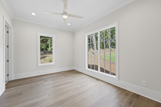 spare room with recessed lighting, wood finished floors, a wealth of natural light, and baseboards