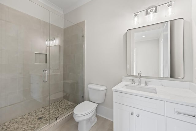 bathroom with toilet, a shower stall, baseboards, and vanity