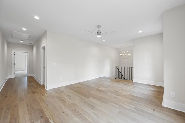 spare room featuring ceiling fan with notable chandelier, light wood-type flooring, and recessed lighting