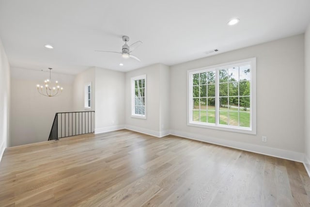 unfurnished room featuring light wood finished floors, recessed lighting, visible vents, baseboards, and ceiling fan with notable chandelier