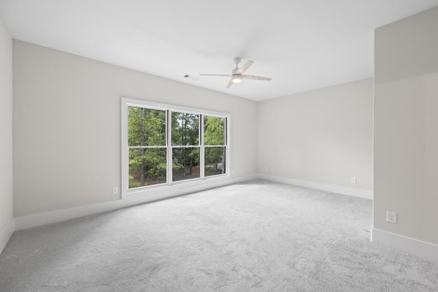 spare room featuring a ceiling fan, carpet flooring, visible vents, and baseboards