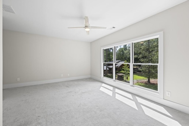 carpeted spare room with visible vents, ceiling fan, and baseboards