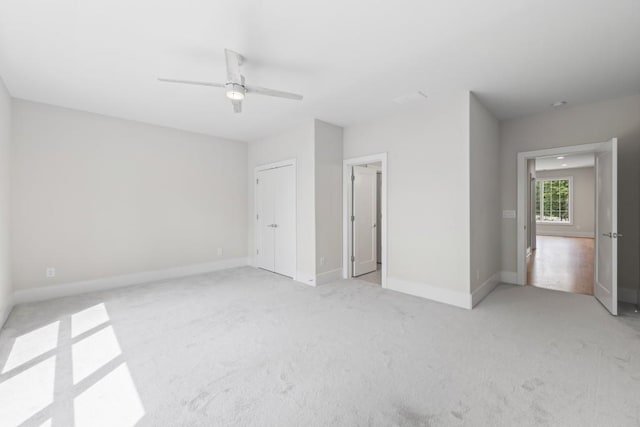 unfurnished bedroom featuring light carpet, ceiling fan, and baseboards