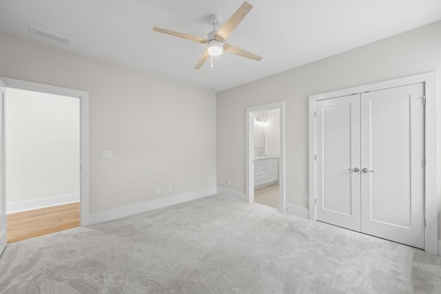 unfurnished bedroom with baseboards, visible vents, connected bathroom, and light colored carpet