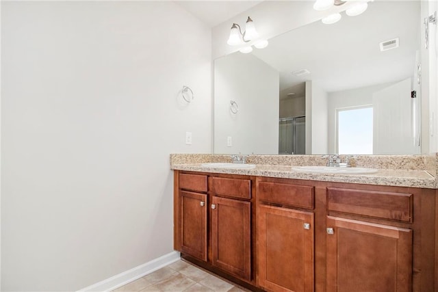 full bath with a sink, visible vents, an enclosed shower, and double vanity