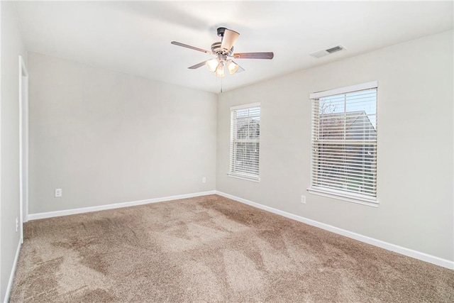 unfurnished room with carpet flooring, baseboards, visible vents, and ceiling fan