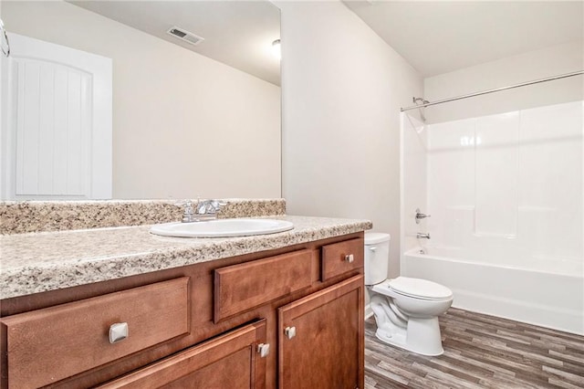 full bath with visible vents, toilet, wood finished floors, vanity, and shower / bathtub combination