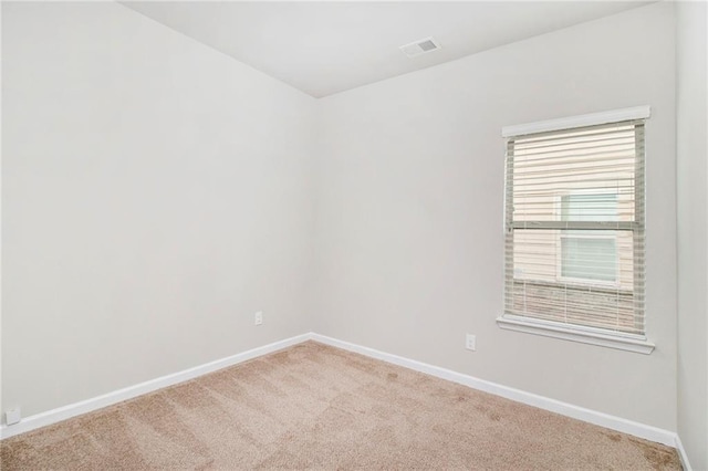 spare room featuring visible vents, baseboards, and carpet