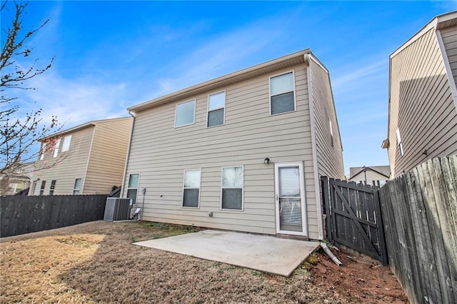 rear view of property with central air condition unit, a fenced backyard, and a patio area