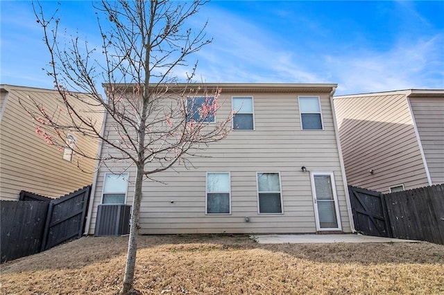 rear view of property featuring a patio, a yard, and a fenced backyard