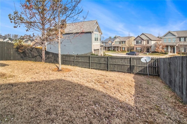 view of yard featuring fence and a residential view