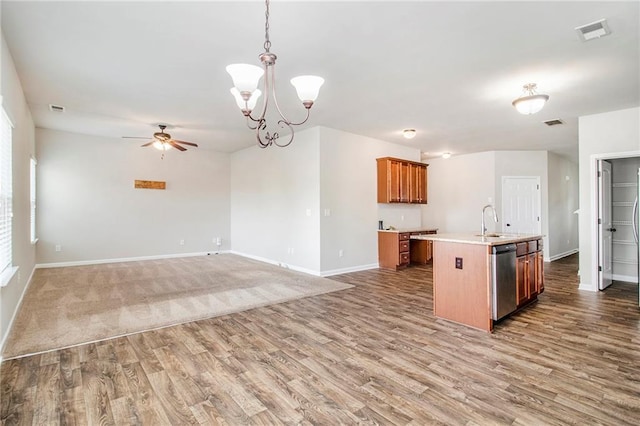 kitchen with light countertops, ceiling fan with notable chandelier, visible vents, and a sink