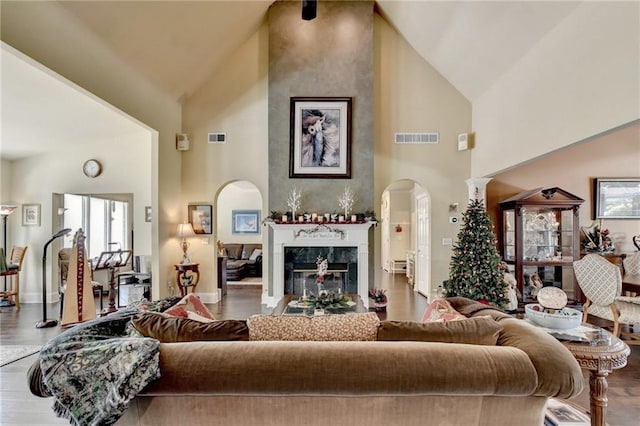 living room featuring a high end fireplace, high vaulted ceiling, and hardwood / wood-style flooring