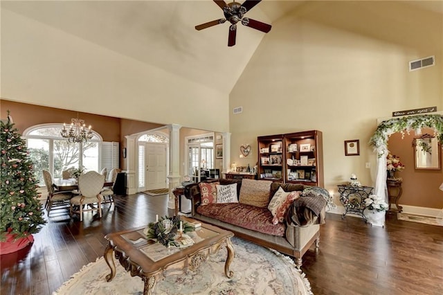 living room with ceiling fan with notable chandelier, a healthy amount of sunlight, high vaulted ceiling, and decorative columns