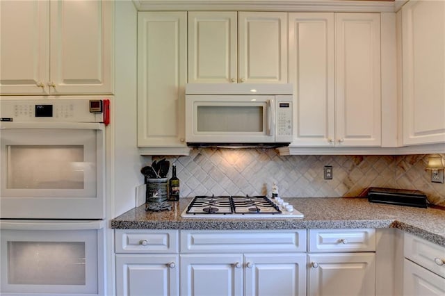 kitchen with white cabinets, white appliances, and tasteful backsplash