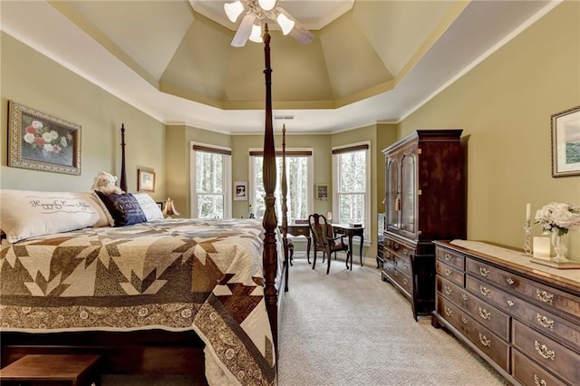 bedroom featuring a raised ceiling, ceiling fan, crown molding, and light colored carpet