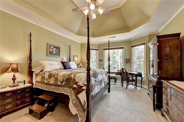 bedroom featuring ceiling fan, light colored carpet, and a tray ceiling