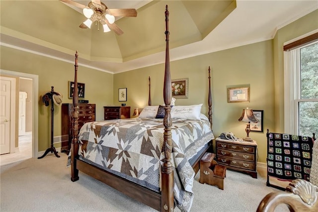 carpeted bedroom featuring a raised ceiling, ceiling fan, and crown molding