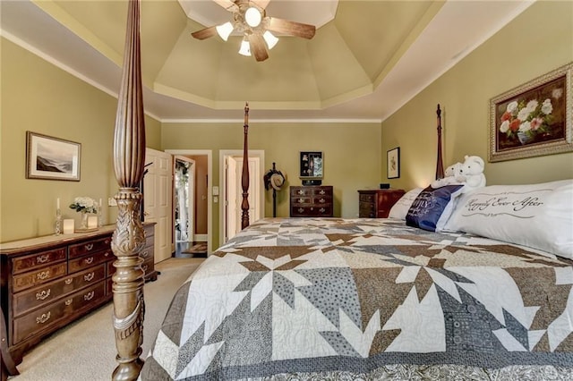 carpeted bedroom featuring a tray ceiling, ceiling fan, and crown molding