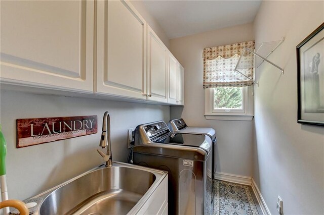 washroom featuring cabinets, washer and dryer, and sink