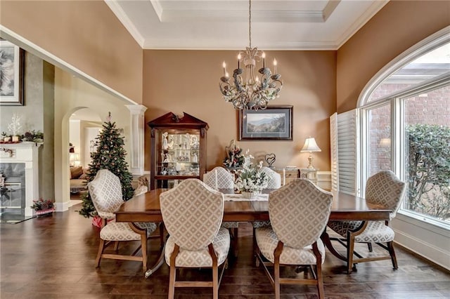 dining area featuring ornate columns, crown molding, dark hardwood / wood-style flooring, and an inviting chandelier