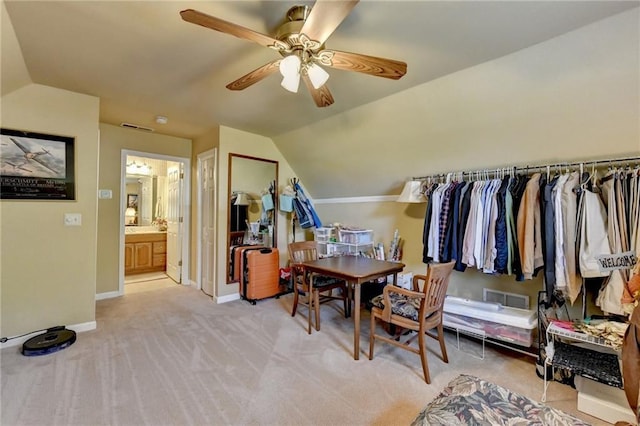 interior space with ceiling fan, light colored carpet, and lofted ceiling