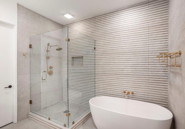 bathroom featuring a freestanding bath and a shower stall