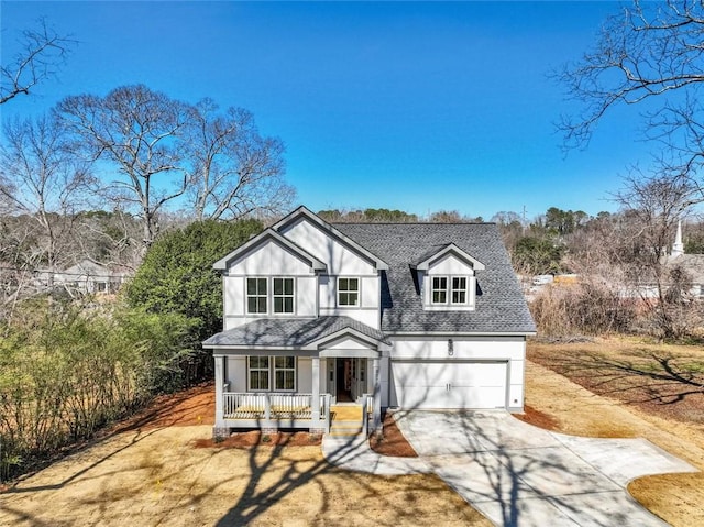 traditional home featuring a porch, concrete driveway, roof with shingles, and a garage