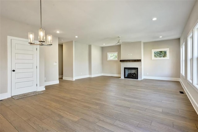 unfurnished living room with recessed lighting, visible vents, wood finished floors, and a tile fireplace