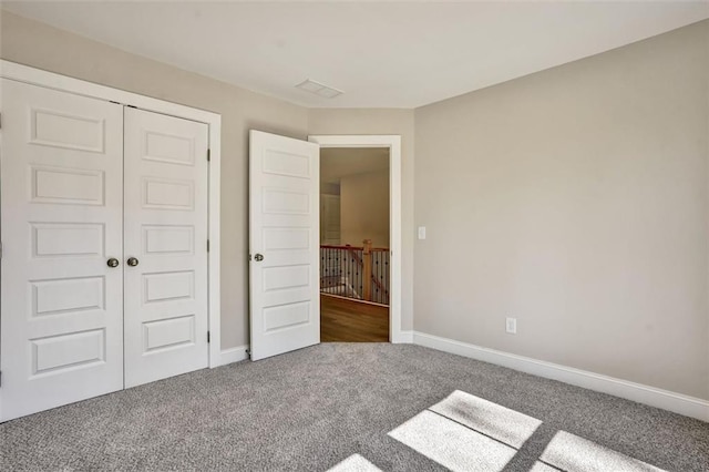 unfurnished bedroom featuring a closet, carpet flooring, and baseboards