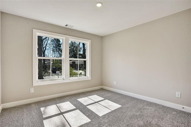 carpeted empty room featuring visible vents and baseboards