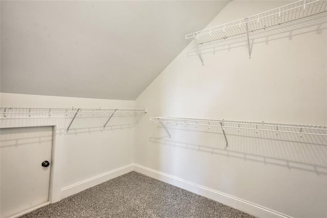 walk in closet with lofted ceiling and carpet flooring