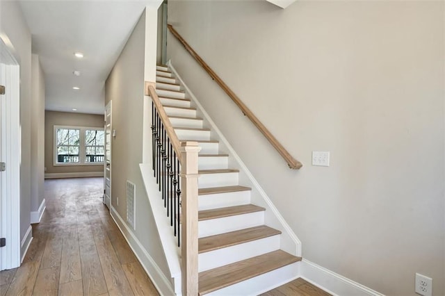 staircase featuring visible vents, baseboards, wood finished floors, and recessed lighting