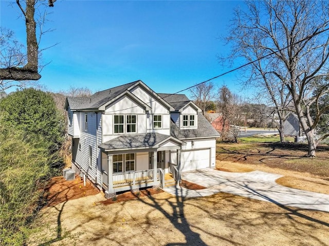 view of front of property with covered porch, a shingled roof, central AC unit, and concrete driveway