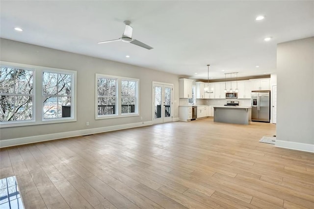 unfurnished living room featuring ceiling fan, baseboards, light wood-style flooring, and recessed lighting