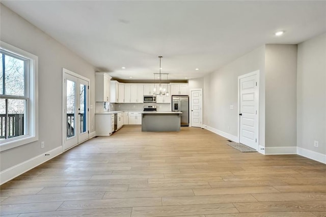 kitchen with recessed lighting, appliances with stainless steel finishes, white cabinetry, light wood-type flooring, and baseboards