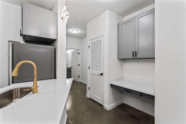 interior space featuring gray cabinetry, concrete floors, and a textured ceiling