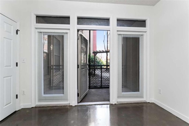 entryway featuring concrete flooring and baseboards