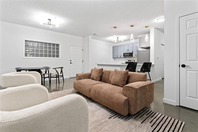 living room with concrete floors, a textured ceiling, and baseboards