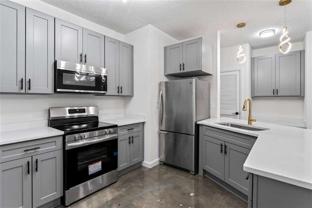 kitchen with a sink, gray cabinets, finished concrete flooring, light countertops, and appliances with stainless steel finishes