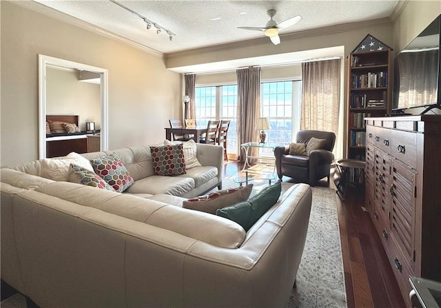 living area with crown molding, rail lighting, dark wood-type flooring, ceiling fan, and a textured ceiling