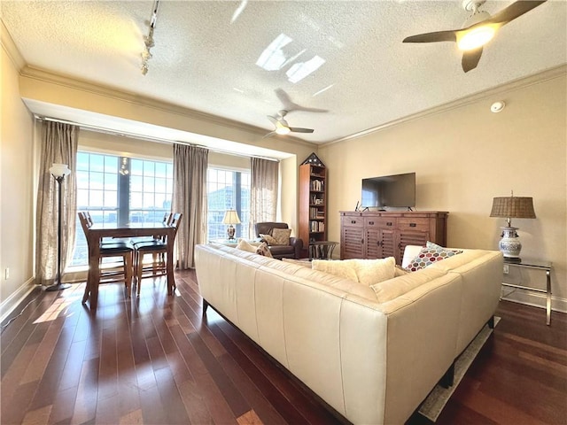 living room featuring ceiling fan, a textured ceiling, dark wood finished floors, and crown molding