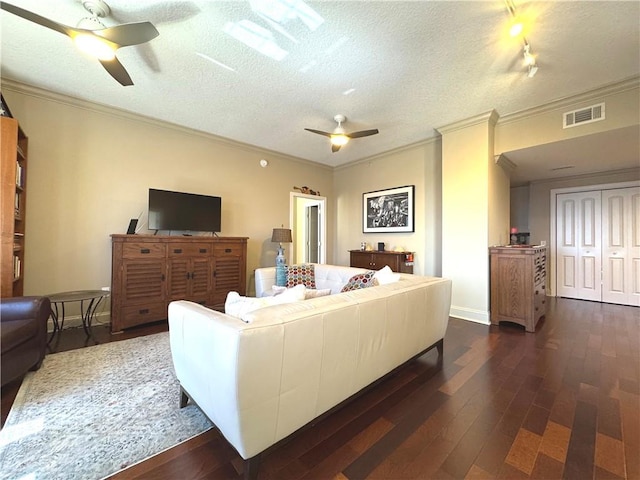 living area featuring dark wood-style flooring, visible vents, ceiling fan, and a textured ceiling