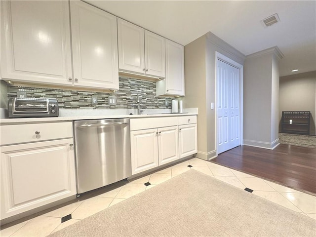 kitchen with light tile patterned floors, light countertops, visible vents, backsplash, and dishwasher