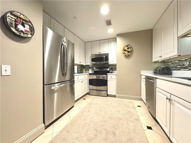 kitchen with tasteful backsplash, visible vents, stainless steel appliances, and light countertops