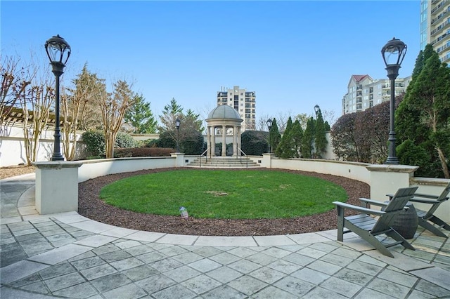 view of home's community featuring a patio, fence, and a lawn