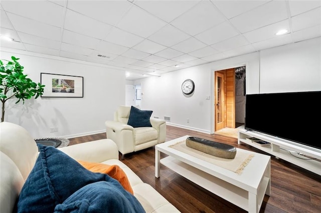 living room featuring baseboards, wood finished floors, a paneled ceiling, and recessed lighting