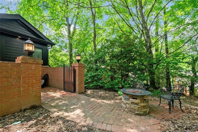 view of patio featuring a gate and an outdoor fire pit